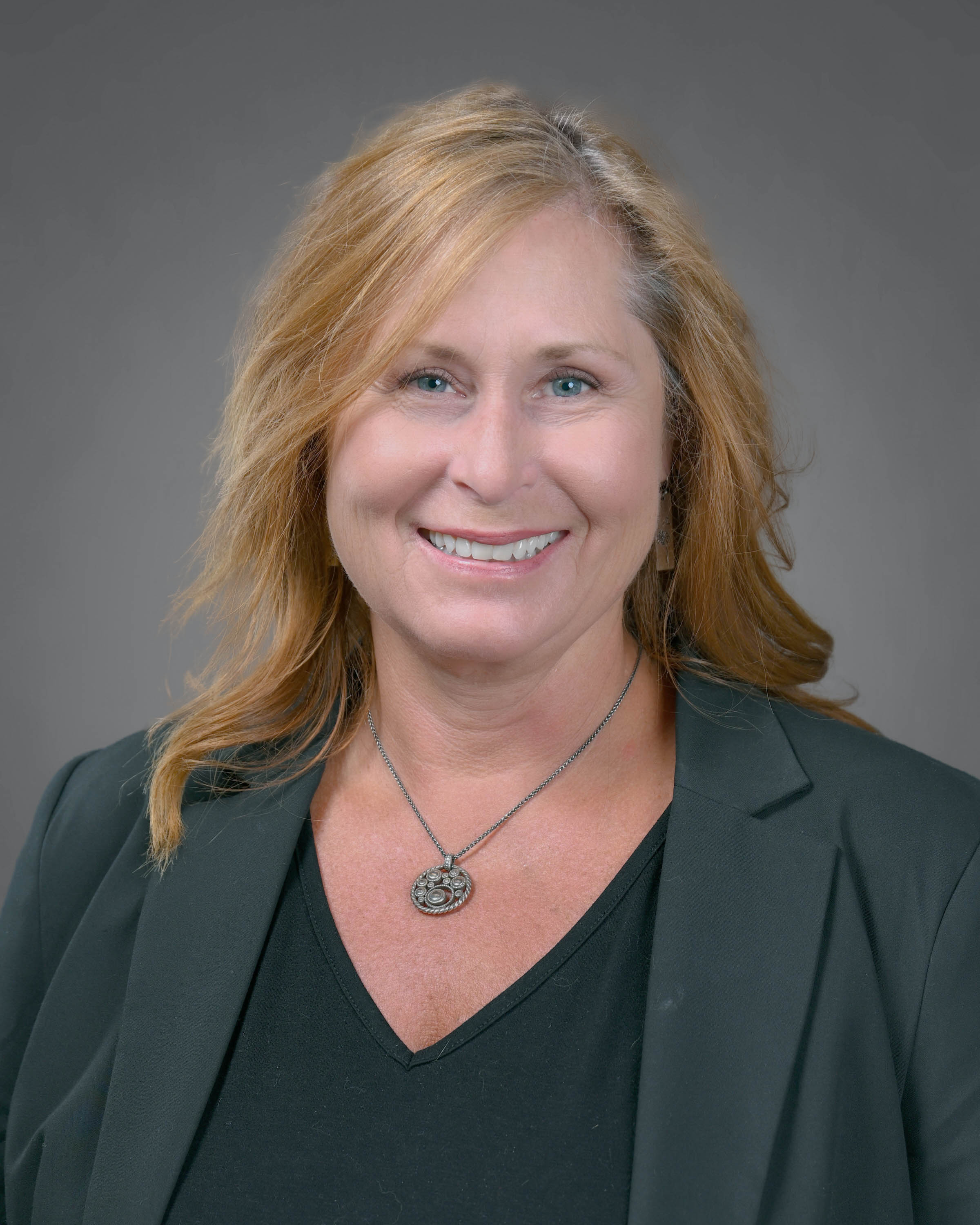 Woman with a dark suit and red hair